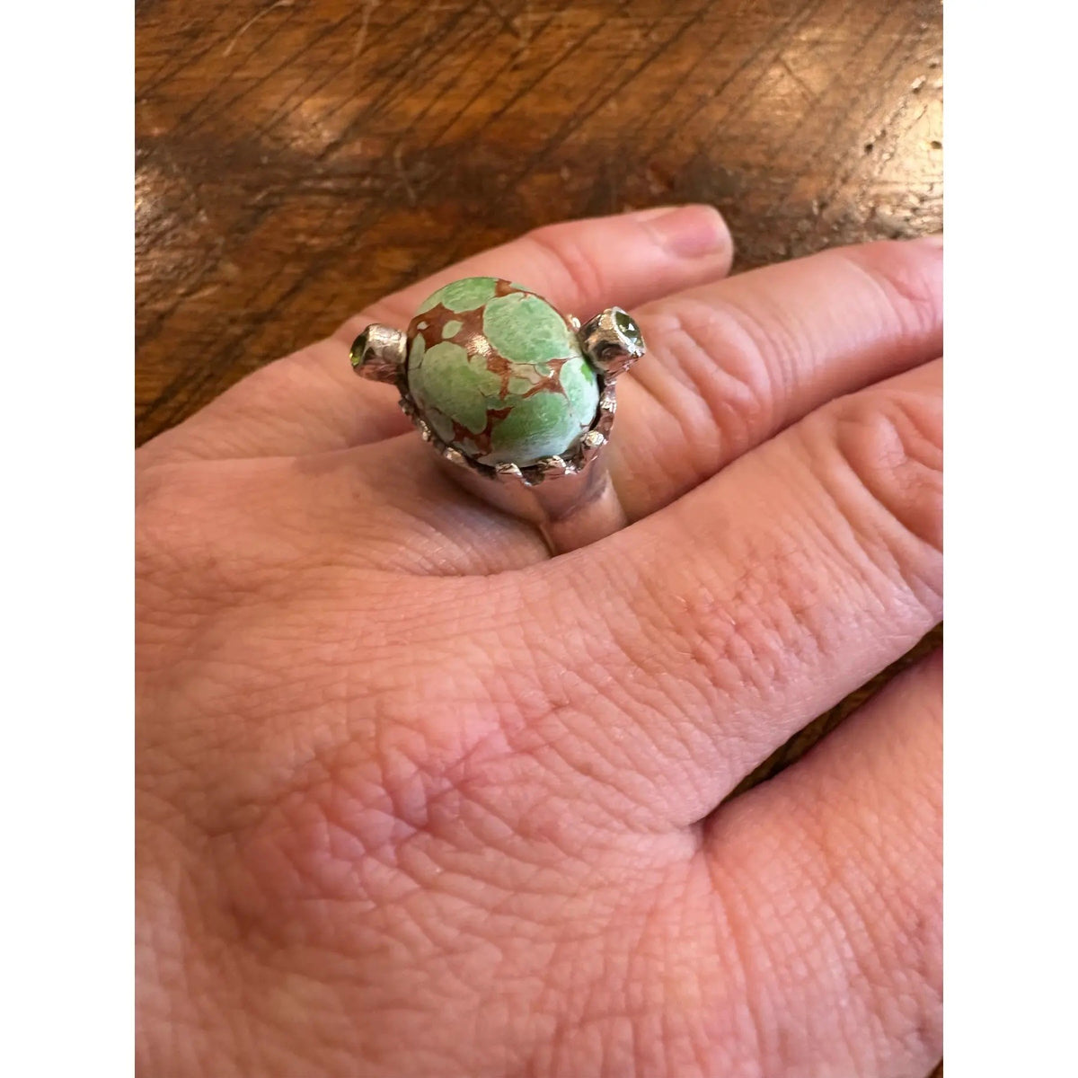 Turquoise Ring in a Crown Shaped Sterling Silver Setting With Two Peridot Gemstones