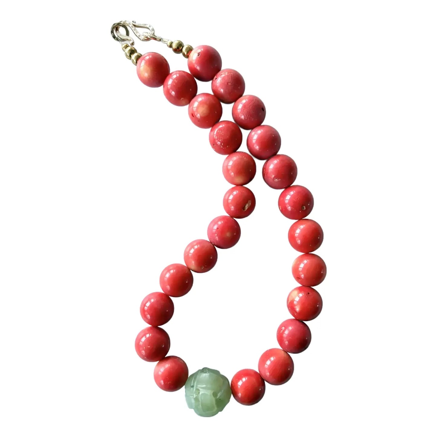Beaded bracelet with red beads and a green accent bead on a white background